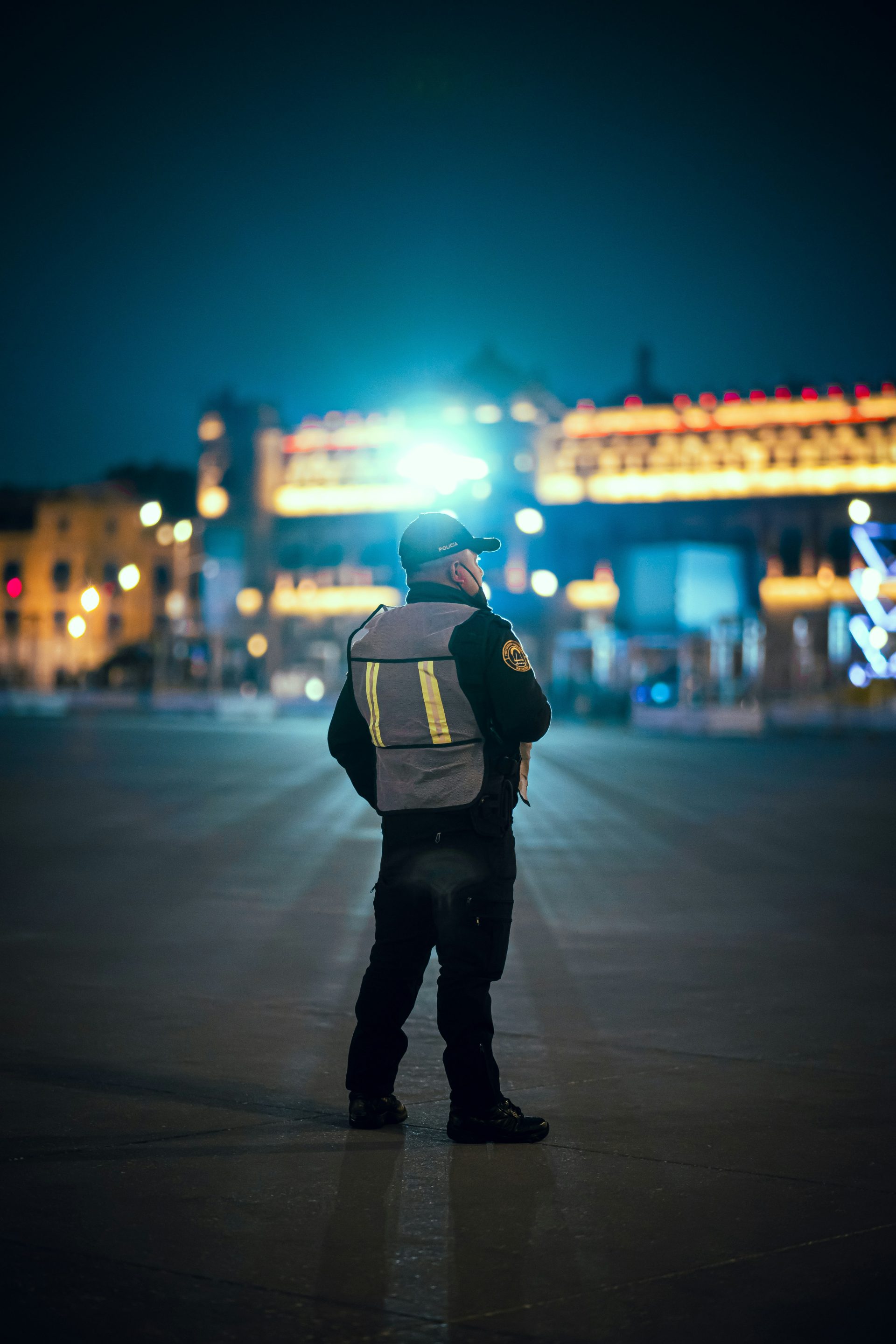 a police officer standing in a parking lot at night